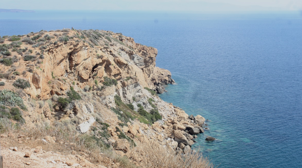 A protective rocky point juts East from the temple