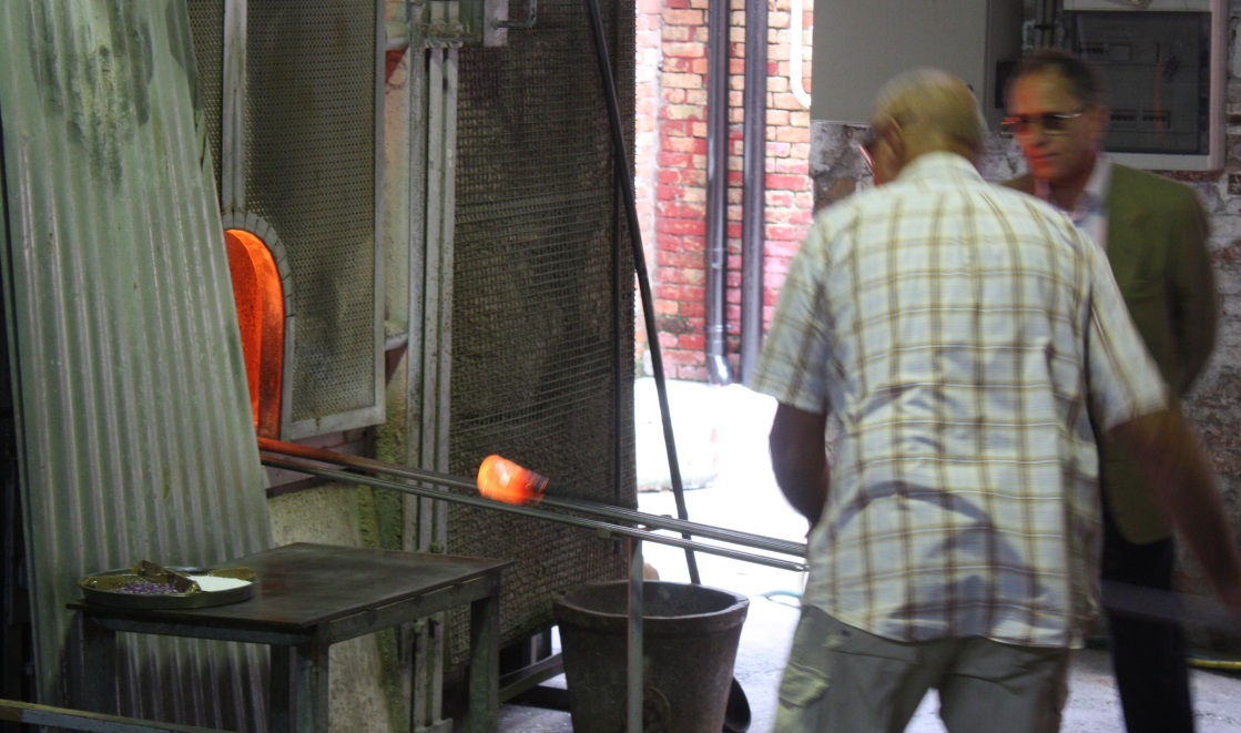 Preparing to blow glass by heating it red hot in the super hot furnace
