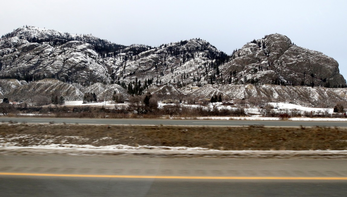 A few farm houses in a mountain setting at Monte Creek from the Trans-Canada Highway