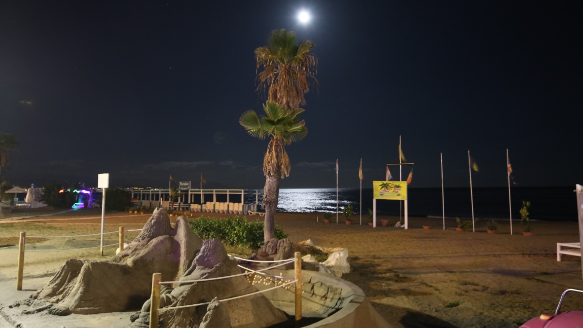 Moon rising over sand sculptures